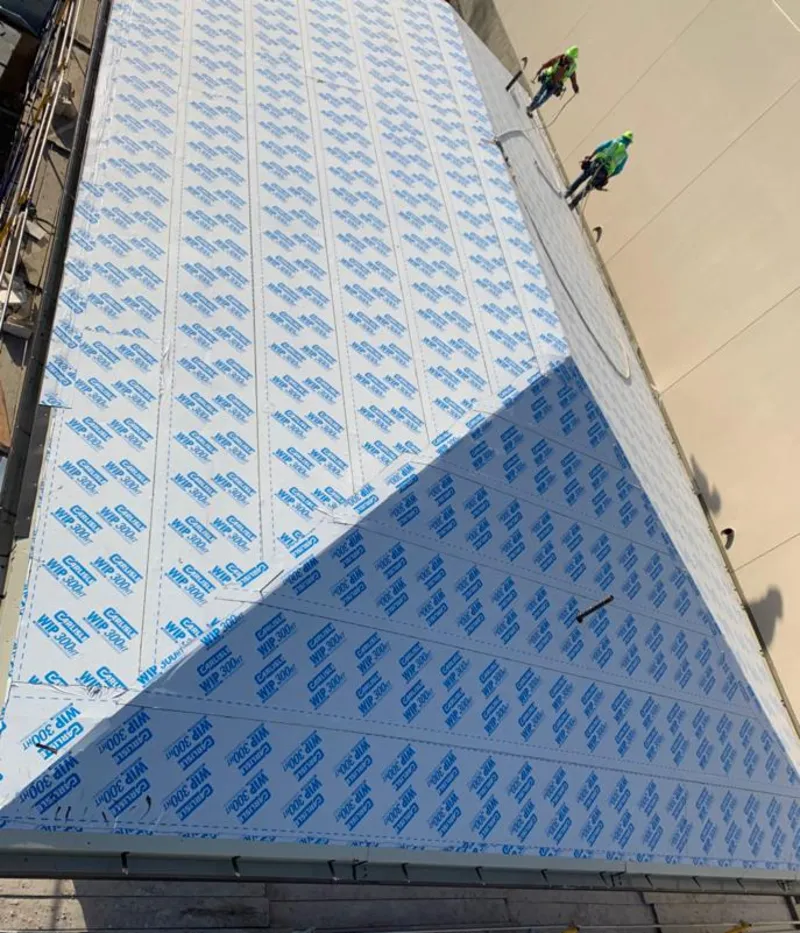 Professional roofers installing underlayment on a metal roof in New Iberia